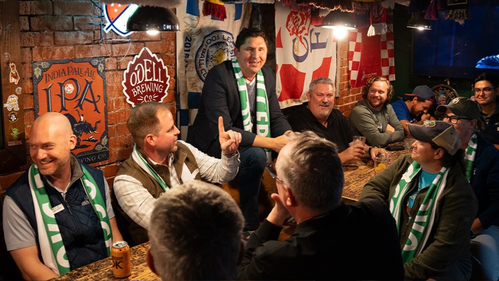 OKC for Soccer fans sitting together and conversing at a table.